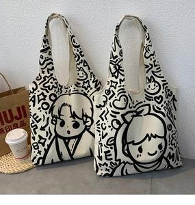 Close-up of canvas tote bag featuring black cartoon character line art and woven texture