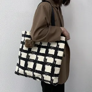 Detail of canvas tote with black hand-drawn grid pattern and cute bear plush charm