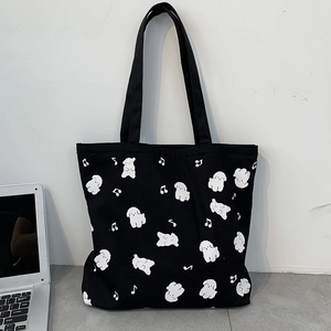 Détail du sac cabas en toile noire avec motif de chien mignon et notes de musique