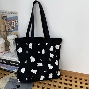 Vue détaillée du sac cabas en toile noire avec imprimés chien blanc et notes de musique