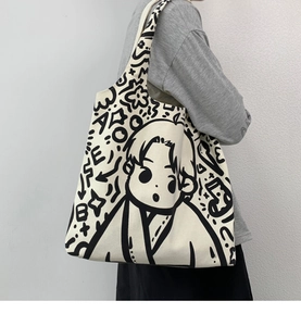 Detail of white canvas tote bag featuring artistic black hand-drawn manga graffiti print