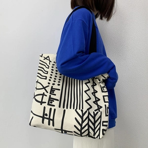 Detail view of large canvas tote bag with tribal geometric print and black shoulder strap