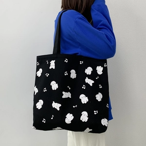 Détails de chiots blancs et notes de musique sur un sac fourre-tout noir en toile
