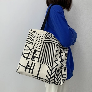 Detail of canvas tote bag with black abstract geometric art lines and reinforced straps