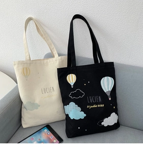 Detailed close-up of thick canvas tote bags with hot air balloon and cloud prints