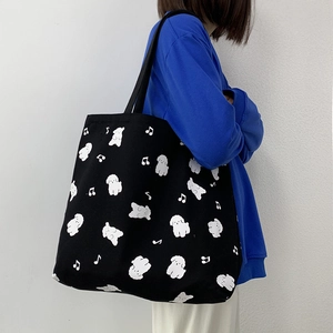Détail du sac fourre-tout en toile noire avec motif chien blanc et notes de musique