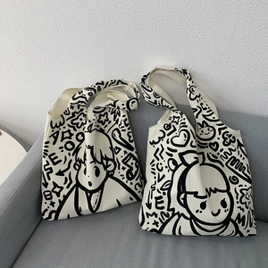 Detail of minimalist cream canvas tote bags with black doodle art and LOVE lettering