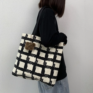 Canvas tote bag with black and white grid patterns and a cute brown plush bear charm