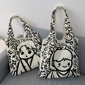 Close-up of beige canvas tote bags with black line art cartoon graffiti and zipper detail