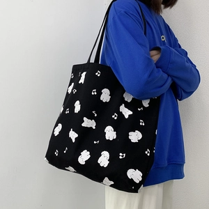 Détail du grand sac cabas noir en toile avec motifs chiots blancs et notes de musique