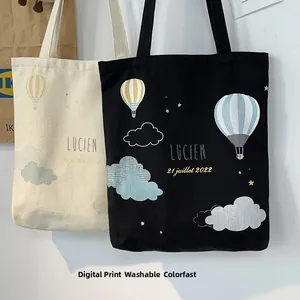 Detail of canvas tote bags with hot air balloon prints and Lucien text branding