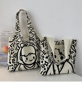 Detailed close-up of ivory canvas tote bags featuring black manga girl art and graffiti
