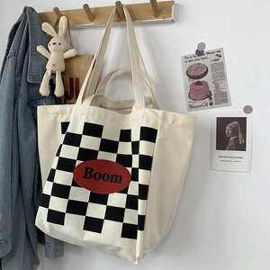 Detail of canvas tote bag featuring checkerboard pattern and Boom letter patch