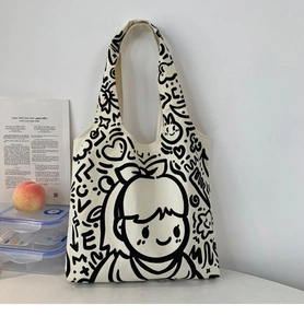 Detail of off-white canvas tote bag featuring a black smile girl doodle and sturdy handles