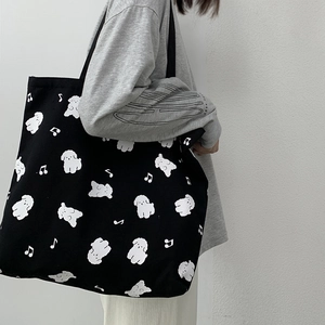 Détail latéral d'un grand sac cabas en toile noir avec imprimé chien blanc