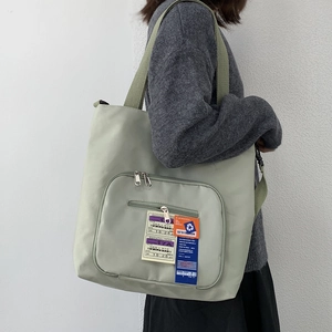 Seitenansicht der olivgrünen Nylon-Einkaufstasche mit kreativen Flughafenschild-Drucken