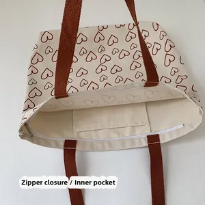 Detail of canvas tote bag showing the zipper closure and functional internal pocket