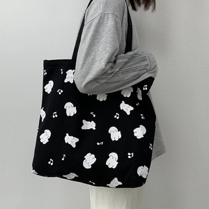 Détail du sac fourre-tout noir en toile avec motif de chien blanc et notes de musique