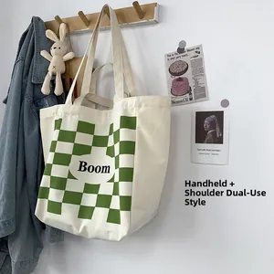 Detail of canvas tote bag with green checkerboard pattern and dual shoulder straps