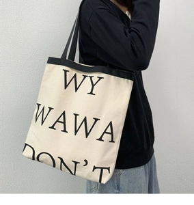 Detail of canvas tote bag with WY WAWA DON'T text and high-capacity shoulder straps