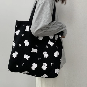 Détail du sac cabas en toile noire avec imprimé chien mignon et bandoulière résistante