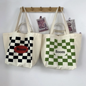 Detail of canvas tote bags featuring black and green checkerboard prints and Boom logo