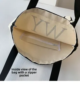 Interior view of off-white canvas tote showing large YW print and inner zipper pocket