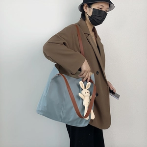 Light blue nylon tote bag with brown leather straps and cute plush rabbit charm
