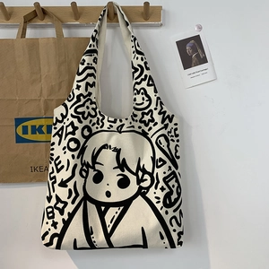 Minimalist canvas tote bag with cartoon boy print shown in a natural lifestyle setting