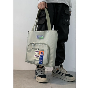 Details der hellgrünen Nylon-Tragetasche mit Vintage-Aufnähern und Reißverschlusstasche