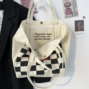 Detail showing magnetic snap closure and inner zipper pocket of the canvas tote bag