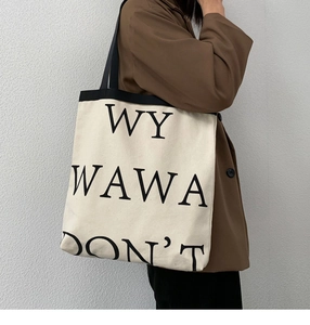 Detail of minimalist canvas tote with black letters and thick straps for students