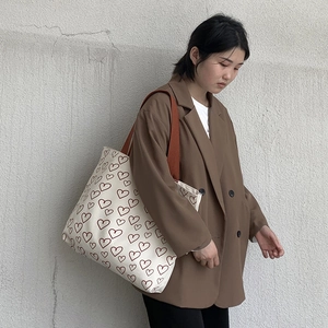 Asian model wearing a minimalist canvas tote bag with red heart prints and wide straps