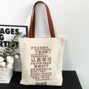 Detail of canvas tote bag with brown handles and motivational Chinese slogans