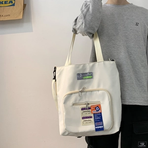 Detailansicht einer cremefarbenen Canvas-Tragetasche mit Streetstyle-Boardingpass-Grafiken