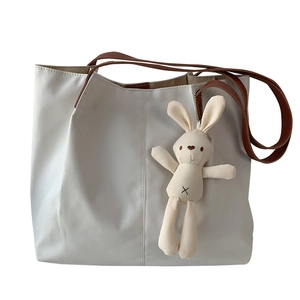 Minimalist beige canvas tote bag with brown straps and cute knitted bunny charm
