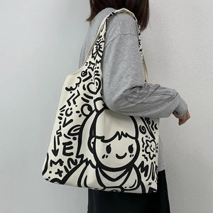 Large beige canvas tote bag with black hand-drawn graffiti and cartoon girl design