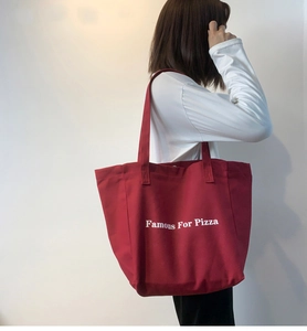 Détail du grand sac cabas en toile rouge avec imprimé typographique de pizza blanc