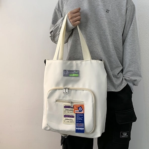 Makroansicht der weißen Canvas-Tasche mit Industrie-Patches und Reißverschlussdetails