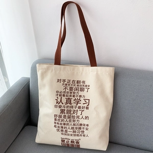 Close-up of cream canvas tote bag with brown straps and inspirational Chinese text