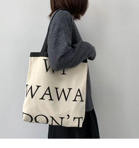 Detail of minimalist canvas tote bag with black letter print and reinforced handles