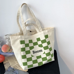 Detail of canvas tote bag showing green checkerboard pattern and magnetic snap button closure