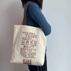 Detail of canvas tote bag with brown straps and inspirational Chinese text print