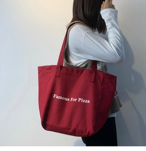 Détail du grand sac cabas en toile rouge avec lettrage blanc et doubles poignées