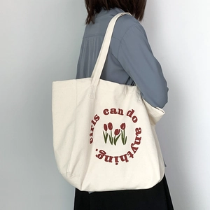 Minimalist tulip canvas tote bag with Girls Can Do Anything print worn by a model