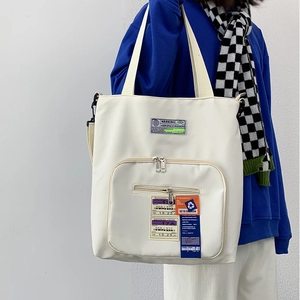 Detailaufnahme der weißen Funktionstasche mit Reißverschlusstaschen und Street-Style-Labels