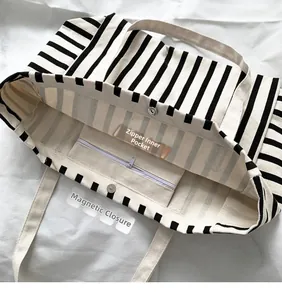 Detail view of stripe canvas tote bag with zipper inner pocket and magnetic snap closure