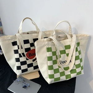 Close-up of checkerboard canvas tote bags featuring Boom logo and metal snap closure
