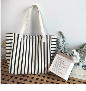 Detailed texture of black and white striped canvas tote bag on a wooden table
