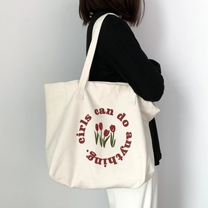 Detail of tulip canvas tote bag featuring red floral print and inspirational quote